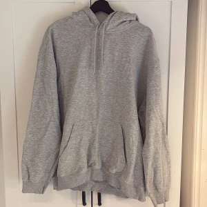 Grå hoodie från H&M - En klassisk grå hoodie från H&M i relaxed fit. Tröjan har huva med dragsko och en stor magficka framtill. Perfekt för en avslappnad stil och enkel att matcha med det mesta💕