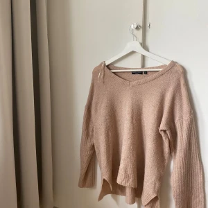 Beige stickad tröja  - Mysig beige/rosa stickad tröja med v-ringad hals och lång ärm. Tröjan har en avslappnad passform och är perfekt för kyligare dagar. Enkel att matcha med både jeans och kjol. Pris diskuteras💘