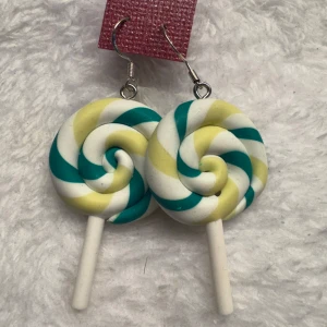 Örhängen i form av klubbor - Säljer ett par unika örhängen formade som klubbor i spiral med färgerna vit, gul och grön. Perfekt för dig som vill sticka ut med ett lekfullt smycke!