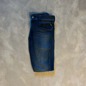 Replay Wallys - Säljer ett par mörkblå jeansbyxor från Replay med klassisk femficksdesign och raka ben. Jeansen har en snygg tvätt och detaljerade sömmar, samt Replay-logga på bakfickan. Perfekta för dig som gillar stilrena och tidlösa jeans. W28 L31