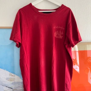 Röd t-shirt från Bianca Chandôn - Röd t-shirt från Bianca Chandôn med tryck på bröstet och stort tryck på ryggen med texten 'Legendary House of Bianca'. Klassisk passform och rund halsringning. Perfekt för dig som gillar streetwear och vill sticka ut med en unik design.