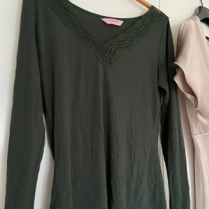  Intimissimi likande ifrån hunkemönller🖤 - Säljer en mörkgrön långärmad topp från Hunkemöller med v-ringning och fina spetsdetaljer längs halsringningen. 