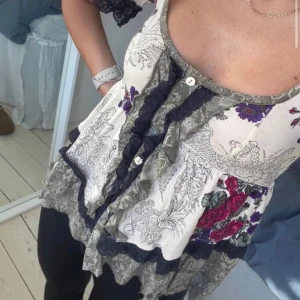 Blommig blus med spetsdetaljer från Odd molly - Supersöt blus från Odd molly med blommigt mönster. Blusen har knappar framtill och korta ärmar med spetskanter. 