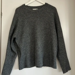 Grå stickad tröja från Primark - Mysig grå stickad tröja från Primark med rund halsringning och långa ärmar. Perfekt för kyligare dagar och enkel att matcha med olika outfits. 