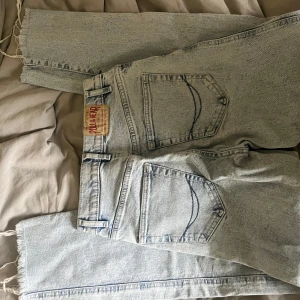 Ljusblå jeans från Pull&Bear - Säljer ett par ljusblå jeans från Pull&Bear med raka ben och fransiga benslut. Klassisk femficksmodell med dragkedja och knapp. Perfekta för en avslappnad stil.💗💗