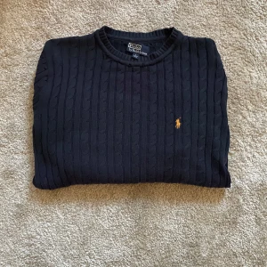 Mörkblå stickad tröja från Polo Ralph Lauren - Skit snygg mörkblå tröja från Ralph Laurent i bra skick. Storlek L men passar S-M. Hör av dig ifall du undrar över något