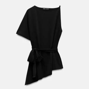 Svart asymmetrisk topp med knyt från Zara - Säljer en svart topp från Zara med asymmetrisk skärning och knytband i midjan. Toppen har kort ärm på ena sidan och en snygg, modern siluett. Endast använd en gång🖤