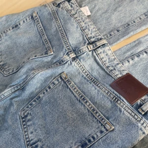 Ljusblå jeans  - Ljusblå jeans från Carlings med raka ben och slitningar över knäna, 
