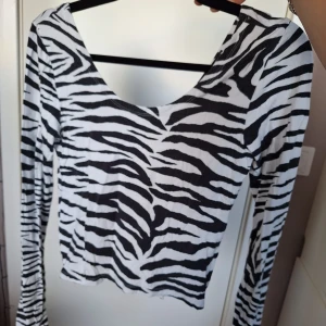 Zebramönstrad långärmad topp - En långärmad tajt topp med zebramönster i svart och vitt. Den är hyfsat kort i längden så jag skulle klassa den som croppad. Ryggen är precis som framsidan. Supercool och snygg!🤍🖤