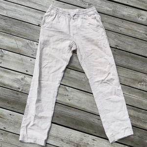 Beige linnebyxor - Säljer ett par ljusbeige linnebyxor med avslappnad passform och resår i midjan. Perfekta nu när sommaren närmar sig och enkel stil. Byxorna har raka ben och sidfickor. Nypris: 499kr. Mitt pris: 260kr
