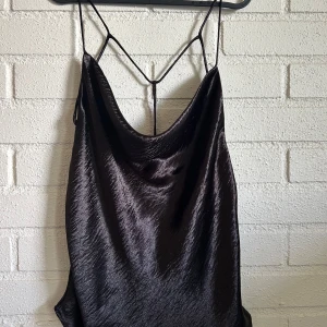 Svart topp - En svart topp från gina tricot i storlek 44 Fint skick, ser nästan ny ut Snörad i ryggen o silkes material på utsidan Hör av er vid frågor eller mer bilder!🌷