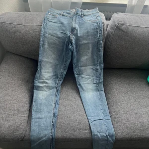 Ljusblå jeansbyxor - Säljer ett par ljusblå jeansbyxor med klassisk femficksdesign och normal passform. Jeansen har en något tvättad look och raka ben. Perfekta till vardags för en avslappnad stil.