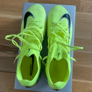 Nike Mercurial fotbollsskor i neon - Säljer ett par Nike Mercurial fotbollsskor som är som nya. Skick 10/10 använda 2-3 träningar.  Det är AG (konstgräs) dobbar. (Box medföljer) köpta från unisport. Hör av er om ni har frågor :) 
