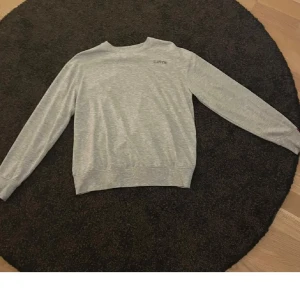Grå sweatshirt från Levi's - Säljer en enkel och stilren grå sweatshirt från Levi's. Tröjan har rund halsringning och långa ärmar, perfekt för en avslappnad look. Passar dig som gillar klassiska basplagg.