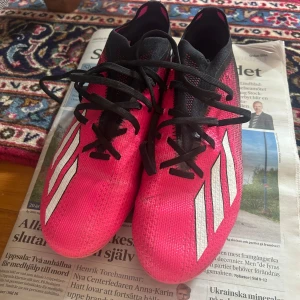 Rosa fotbollsskor från Adidas - Säljer ett par rosa Adidas fotbollsskor med svarta och vita detaljer. Skorna är knappast använda och i jätte bra skick!
