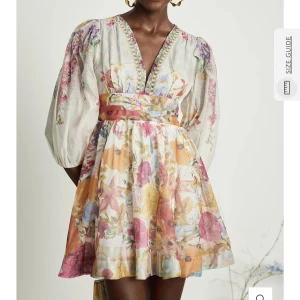 Blommig kortklänning med v-ringning och volang - Superfin kortklänning med blommigt mönster i pastellfärger. Djup v-ringning med dekorativa detaljer, markerad midja och volangkant nertill. Helt ny och aldrig använd! Säljer då den var för stor för mig! Nypris 1672kr Jag har dessvärre ingen bilder när jag har på mig den då den inte passade och jag har redan packat ihop den igen!