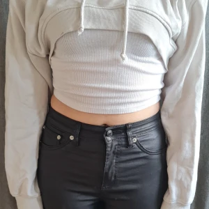 Vit croppad hoodie - Säljer en vit croppad hoodie med långa ärmar, den är inte använd på länge och knappt knvänt den, den har små fläckar av lite smink men jag tror att det går bort i tvätten eller något liknande, vet inte vilken storlek det är då jag oftast klipper bort lapparna för att det klias men skulle gissa på xs eller s då jag testade den och jag själv har s