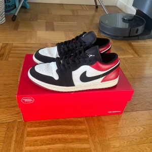 Nike Air Jordan 1 Low, Svart/Vit/Röd - Nypris: 1749kr från Nikes hemsida. Snygga Air Jordan 1 Low sneakers i en klassisk färgkombination. Perfekt för både vardag och speciella tillfällen. Bekväma och stilrena. Använda ett fåtal gånger. Storlek 45,5. Högsta bud vinner