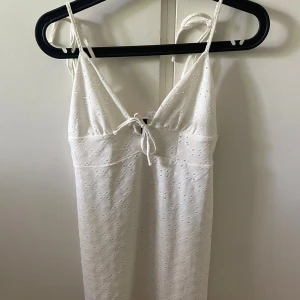Vit söt klänning - Vit kort klänning från HM i storlek S. Den har knytningar på axlarna så man kan reglera själv. Bra skick och perfekt nu till sommaren🌞
