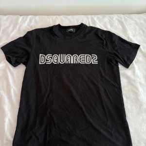 Svart Dsquared2 t-shirt med logga - Svart t-shirt från Dsquared2  Är du intresserad av plagget är de bara att skriva.  Vill du ha billigare genom bundle eller lika feta kläder kolla bara in min profil och gör ett bundle och skriv till mig. M/L
