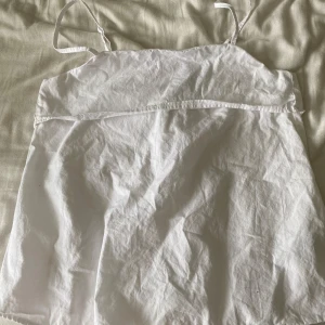 Vit linnetopp från H&M Divided - Säljer en enkel och fräsch vit linnetopp från H&M Divided i storlek XXS. Toppen har smala axelband, rak halsringning och dragkedja i sidan för enkel påklädning. Perfekt till sommaren och lätt att matcha med allt. Aldrig använd!