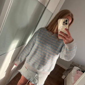 Randig stickad tröja Gina Tricot - Supermysig stickad tröja från Gina Tricot i ljusgrått och ljusblått randigt mönster. Tröjan en rund hals. Perfekt för lager-på-lager och chill dagar. Tröjan är i storlek 146-152 men passar om man har XS-S. Endast använd ett fåtal gånger.