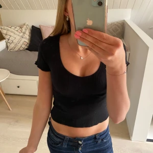 Snygg topp - Svart ribbad topp med V/U ringning. Står st S, men skulle säga att den även passar xs. Eftersom den är ganska kort. Hör av dig vid frågor eller funderingar💕