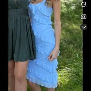 Ljusblå volangklänning - Supersöt ljusblå klänning med volanger. Den är superfin och sitter verkligen perfekt i modellen!! Endast använd 1 gång till ett bröllop!! Perfekt till fester, bal, sommarkvällar och bröllop!!