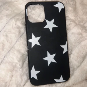 Svart mobilskal med vita stjärnor - Snyggt svart mobilskal med vita stjärnor. Passar iPhone 12, lite använd men bra skick