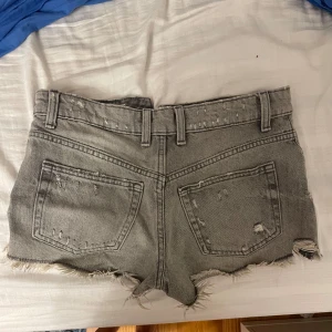 Grå slitna jeansshorts med fransar - Säljer dessa gråa jeansshorts från zara då de inte kommer till användning!💗De är storkel 34 och skriv bara om ni har några frågor! Nypris 350