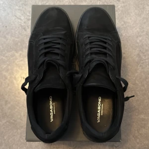 Svarta Vagabond - Snygga svarta sneakers från Vagabond med klassisk snörning och rund tå. Perfekta för en stilren look och passar till många olika outfits. Köpte för ca 1500kr knappt använda. Original box ingår.Pris kan diskuteras. 