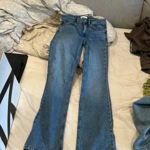 Blå bootcut jeans från Select Jeans - Snygga blå jeans från Select Jeans med klassisk femficksmodell och bootcut-ben. Jeansen har normal passform och är tillverkade i slitstarkt denimtyg. Perfekta för dig som gillar en tidlös look med lite utsvängda ben.