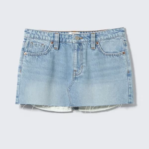 Ljusblå jeanskjol med rå kant - Snygg ljusblå jeanskjol i kort modell med klassiska fem fickor och rå, fransig kant nedtill. Kjolen har en avslappnad passform och stängs med knapp och dragkedja framtill. Perfekt för dig som gillar en cool och enkel stil.