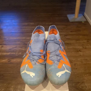 Blå-orange fotbollsskor från Puma - Säljer ett par Puma skor använda en halv säsong. I bra skick,växte ur de för ett litet tag sen väldigt skön sko som skyddar foten bra 
