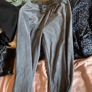 Grå mjukisbyxor med snörning gina kids velour - Mysiga grå mjukisbyxor i mjukt material med dragsko i midjan. Perfekta för chill dagar hemma eller när du vill vara extra bekväm. Raka ben och enkel design som passar till allt.velour från Gina