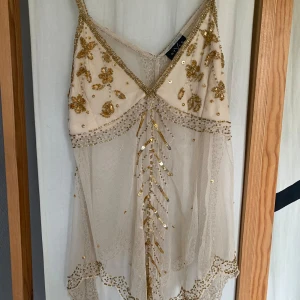 Champagnefärgad y2k topp Style - Superfin y2k topp i champagnefärg från Style. Står ingen storlek men passar S/M. Tappat några pärlor men inget som syns!