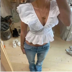 Vit volangtopp - Supersöt vit blus med v-ringning och knytband i ryggen, storlek M men är lite liten i storleken💗
