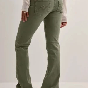 Nelly stitch bootcut jeans - Snygga gröna jeans med bootcut-modell och klassiska bakfickor med dekorativa sömmar. Byxorna har låg midja och är tillverkade i ett mjukt bomullstyg med lite stretch för skön passform. Perfekta för en avslappnad men trendig look. Köpta för 699kr. Storlek 36 med innerbenslängd på 84cm. Har används vid två tillfällen och säljer pga att de inte kommer till användning längre. Hör av dig vid frågor eller önskemål om egna bilder💞pris är diskuterbart