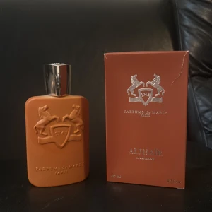 Parfums de Marly Althaïr EdP 125ml - Exklusiv parfym från Parfums de Marly, Althaïr EdP 125ml. Flaskan är matt orange med silverdetaljer lite defekter runt korken annars inget. Sprutad max 8 gånger då den ej va min smak. Fick den i present för några månader sen men aldrig kommit till användning. Säljer nu för en billig peng då jag behöver pengar 