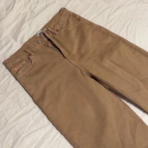 Beige jeansbyxor från 157 - Snygga beige jeansbyxor från 157 i storlek M. Byxorna har en klassisk design med knapp och dragkedja framtill. Perfekta för en stilren look.