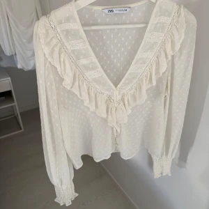 Vit blus från Zara - Vit mesh blus från Zara med prickar på & volanger samt knappar på framsidan.