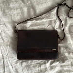 Handväska - Fin väska i brunt läder från danskt märke Belsac. Väskan stängs med magnet och har tre stora fack och ett litet (se bilder). Köpt second hand men har själv aldrig använt. Inga hål, repor eller defekter.