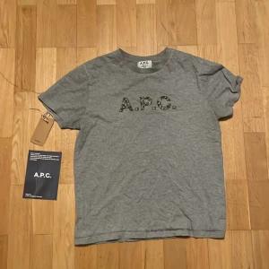 Grå t-shirt från A.P.C. - A.P.C t shirt i ett 8/10 skick köpt direkt från hemsidan. Snygg t shirt för sommaren! Skriv om ni har frågor