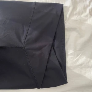 Svarta leggings med omlottmidja - Snygga svarta leggings med en unik omlottmidja som ger en stilren look. Perfekta för både träning och avslappnade dagar. Tillverkade i ett stretchigt material för bästa komfort.