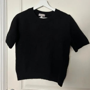 Svart kortärmad tröja - Svart stickad tröja med korta ärmar. 