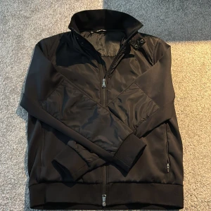 Svart jacka/cardigan från J.Lindeberg - Tja, säljer nu en grymt fet J.Lindberg jacka/cardigan i grymt skick. Säljer pågrund av att den blivit för liten på mig