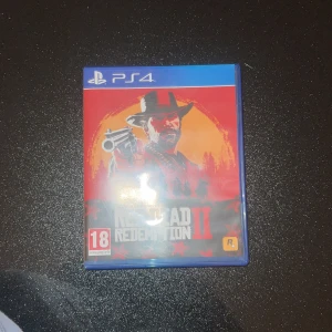 Red Dead Redemption II för PS4 - Säljer Red Dead Redemption II till PS4. Spelet utspelar sig i Amerika 1899 och följer en grupp laglösa på flykt. Perfekt för dig som älskar action och äventyr i en öppen värld. Innehåller både singleplayer och online-läge.