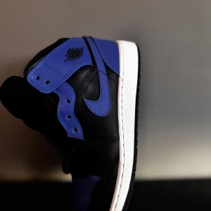 Nike Air Jordans i svart och blått - Snygga Nike Air Jordans i en klassisk svart och blå färgkombination. Skorna har en rund tå och snörning framtill. Perfekta för dig som vill ha en stilren och sportig look.för mer info kontakta. Skicka ett pris om det inte passar dig