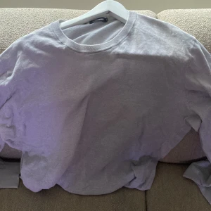 Ljusgrå tröja - Säljer en ljusgrå tröja med rund hals och långa ärmar. Perfekt för en avslappnad stil. Tröjan är i storlek herr XXL och har en enkel design utan mönster.