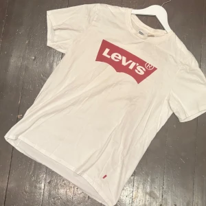 Levi's T-Shirt - Denna riktigt snygga t-shirt från Levi’s är knappt använd och har inga större defekter, förutom en liten,liten fläck på bröstet . Storleken är S men jag skulle säga att den sitter lite större. Modellen på bilden är 188 cm och väger 70 kg. Om ni har några frågor är det bara att skriva!                            /T-Arkivet 👕😁